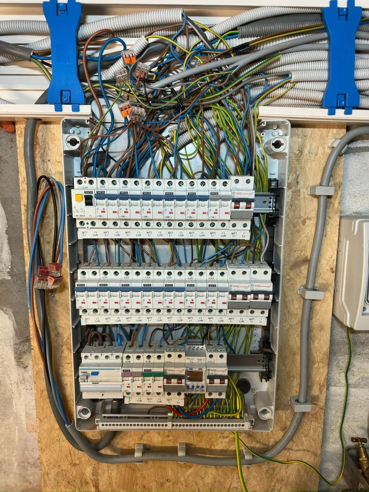 Nieuw verdeelbord in opbouw met drie rijen automaten en de bedrading uit de kabelgoot erboven
