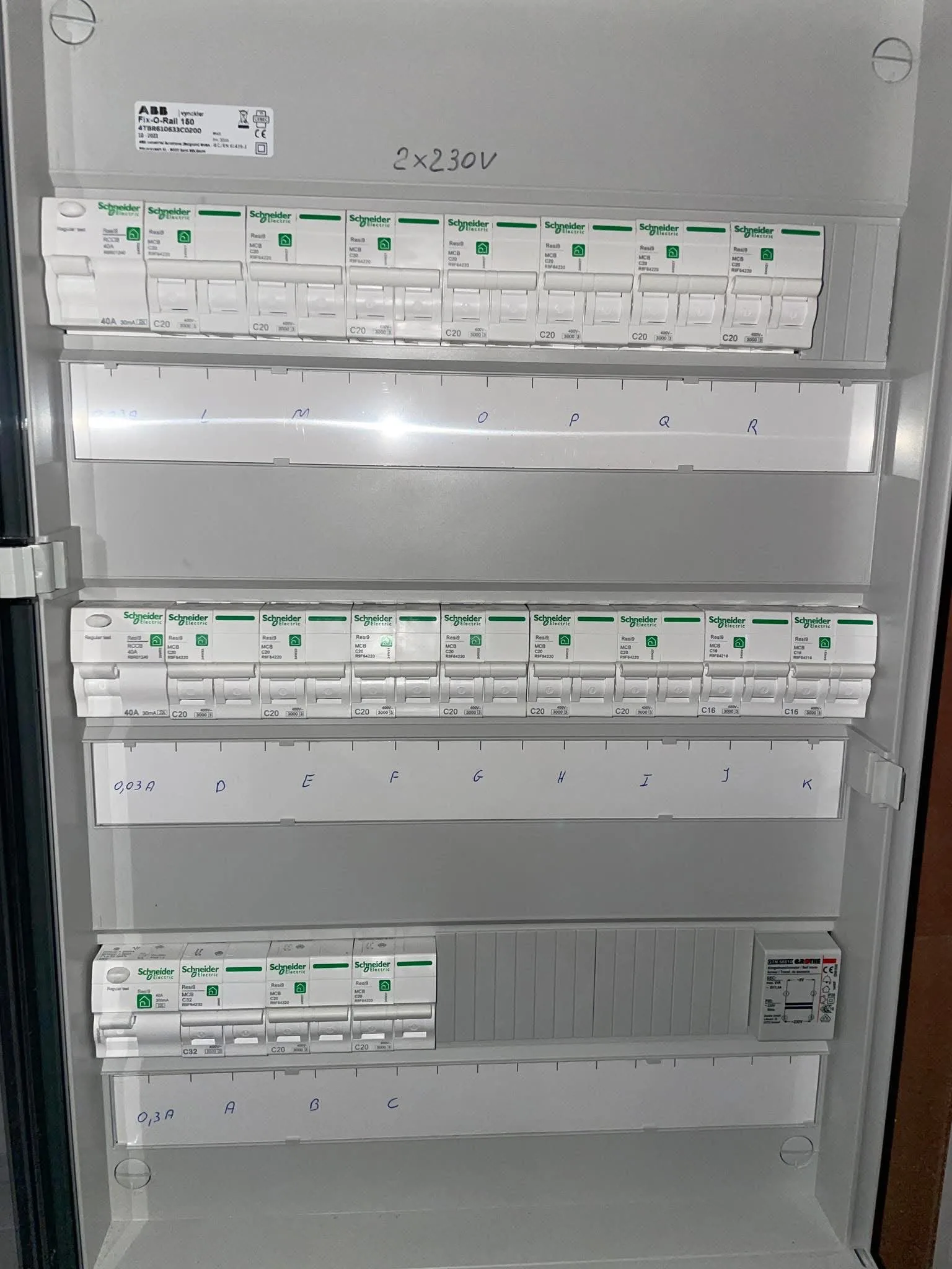 Afgewerkt verdeelbord met drie rijen automaten en differentieelschakelaars, de kringen met letters genummerd